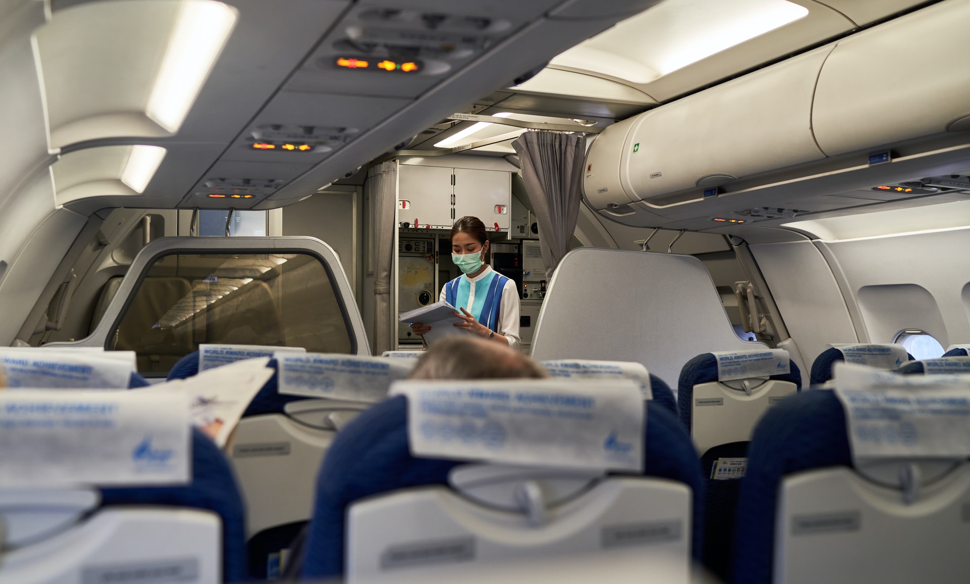 A flight attendant going through mandatory operational procedures checklist.