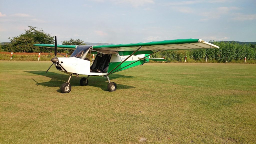 Ultralight airplane parked on a grassy field.