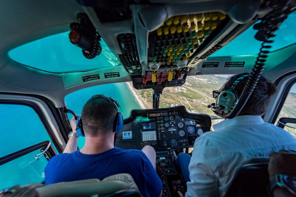 Two pilots in a cockpit of a small airplane discussing flight details. 
