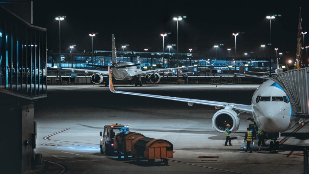 Ground staff is preparing an airplane for a red eye flight. 