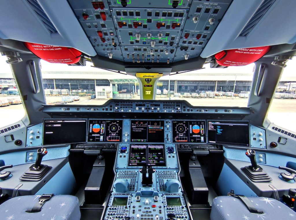 An airplane cockpit with visible GPWS screens illuminated.