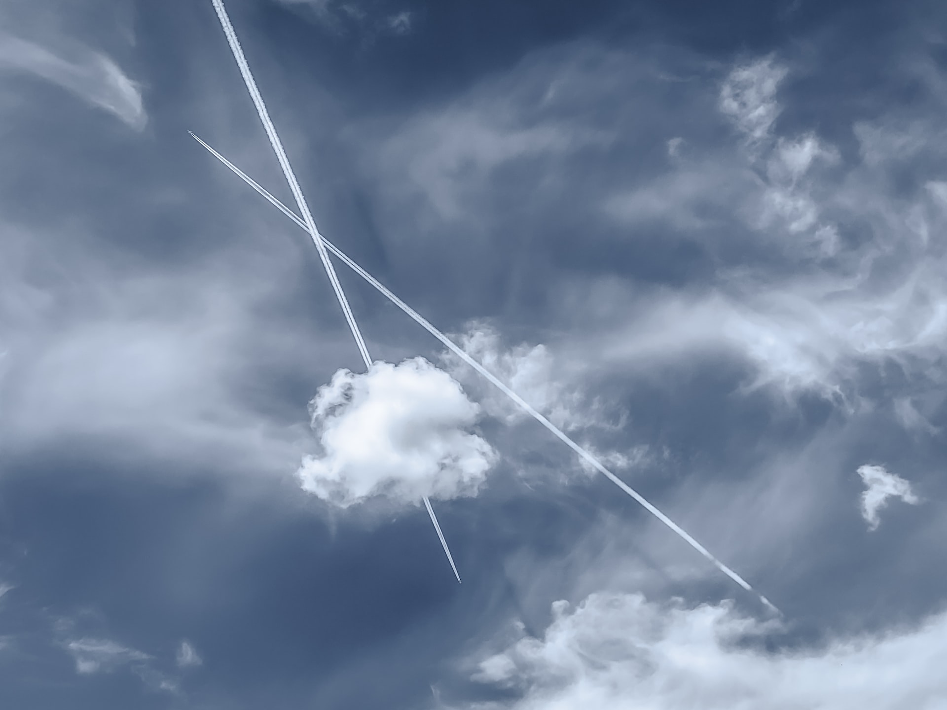 Two airplanes leaving trails in the sky.