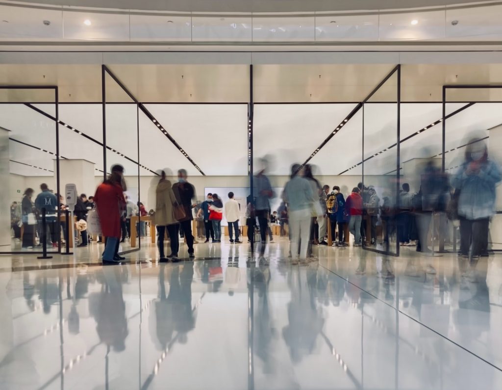 People waiting in line to pass an airport security officer checkpoint.