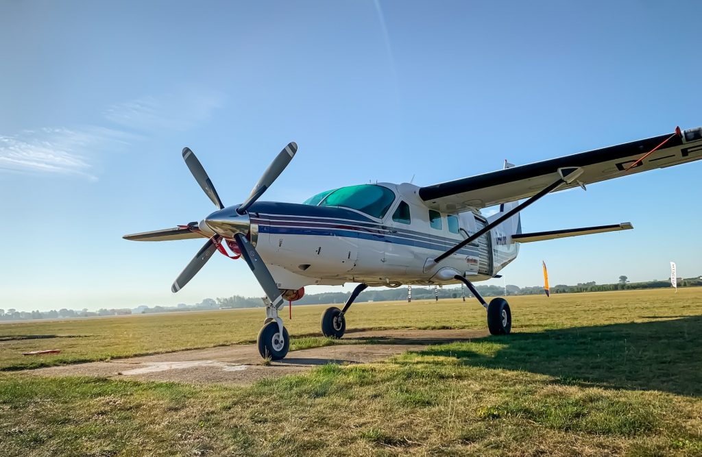 A used airplane stationed in an airfield on a sunny day.