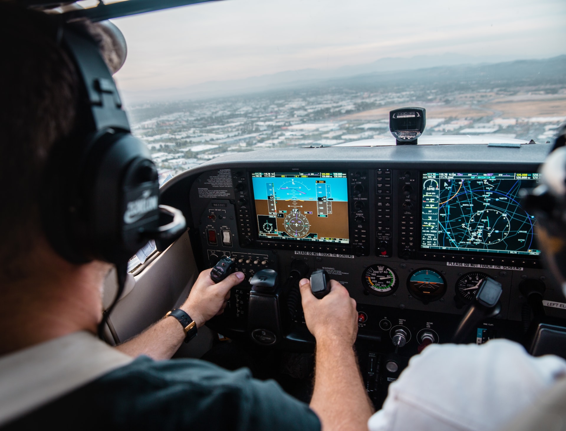 A pilot controlling an airplane and referring to a GPWS.