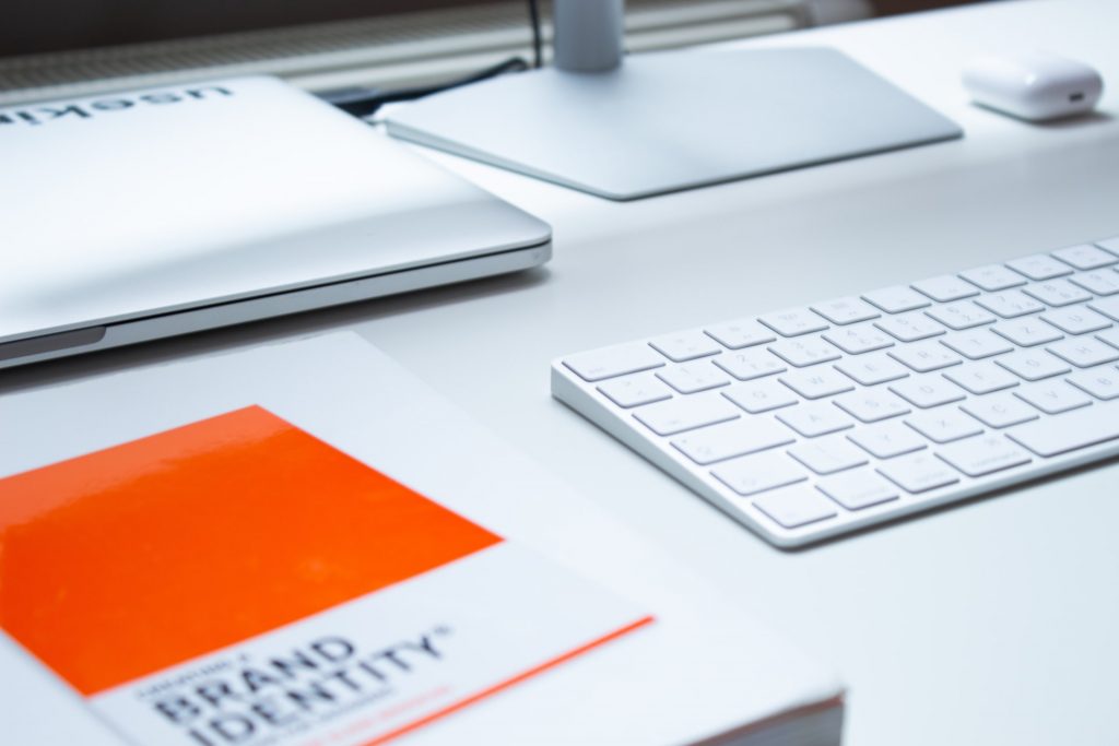 A representation of brand identity building: a brand identity book next to a keyboard on a desk.