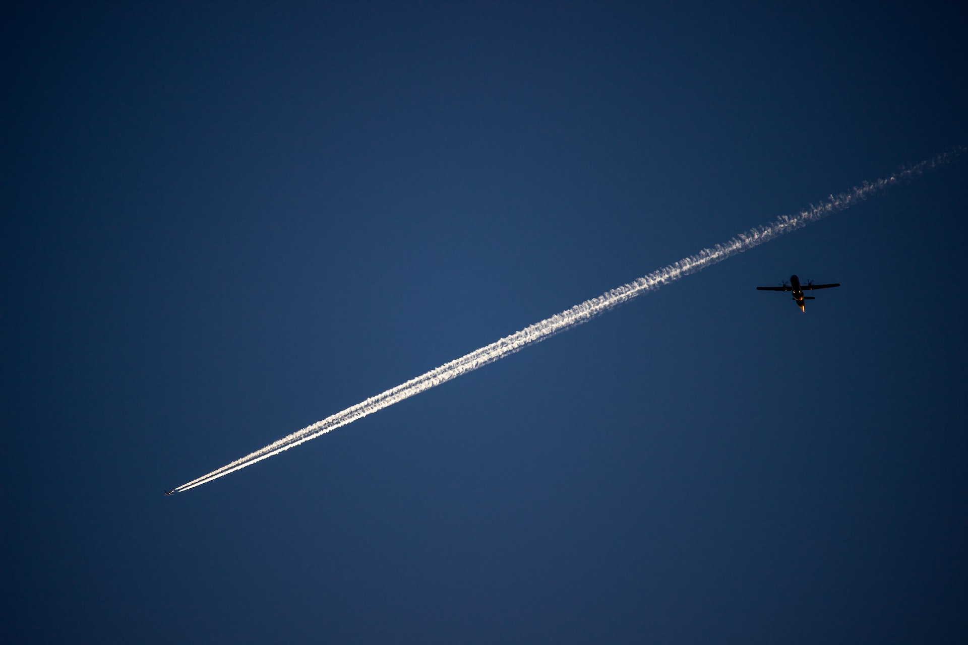 A flying airplane leaving a trail in the sky.