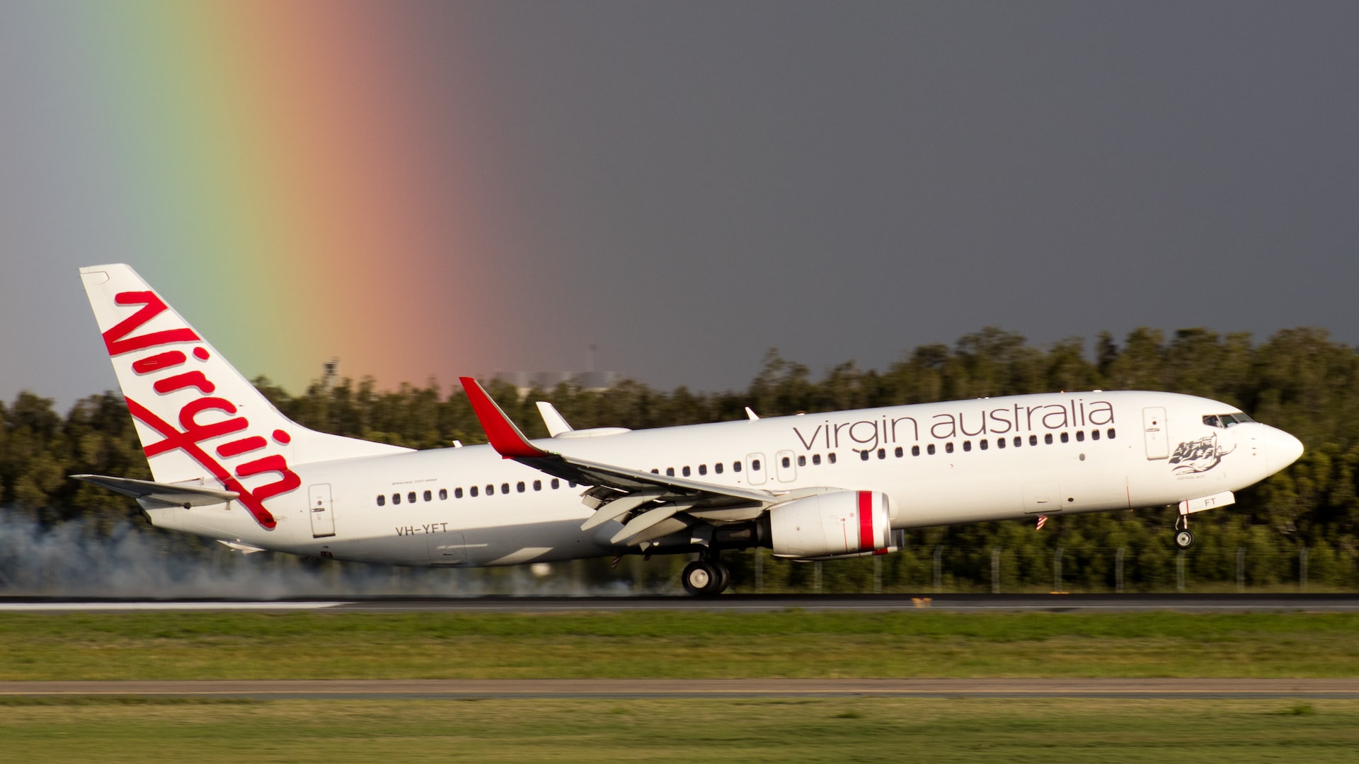 A Virgin Australia airlines plane landing on a runway.