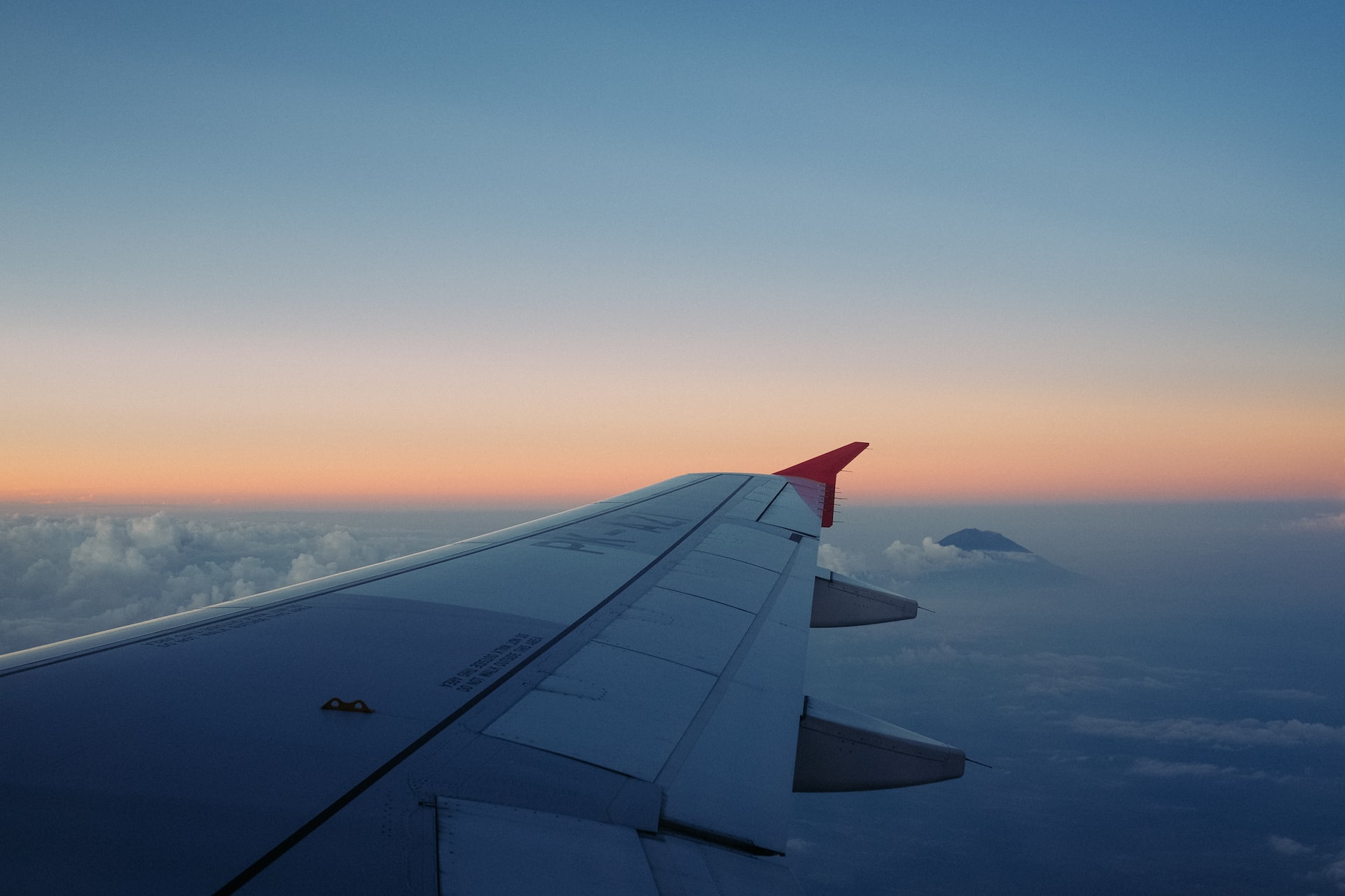 A plane flying at a high altitude at sunset.