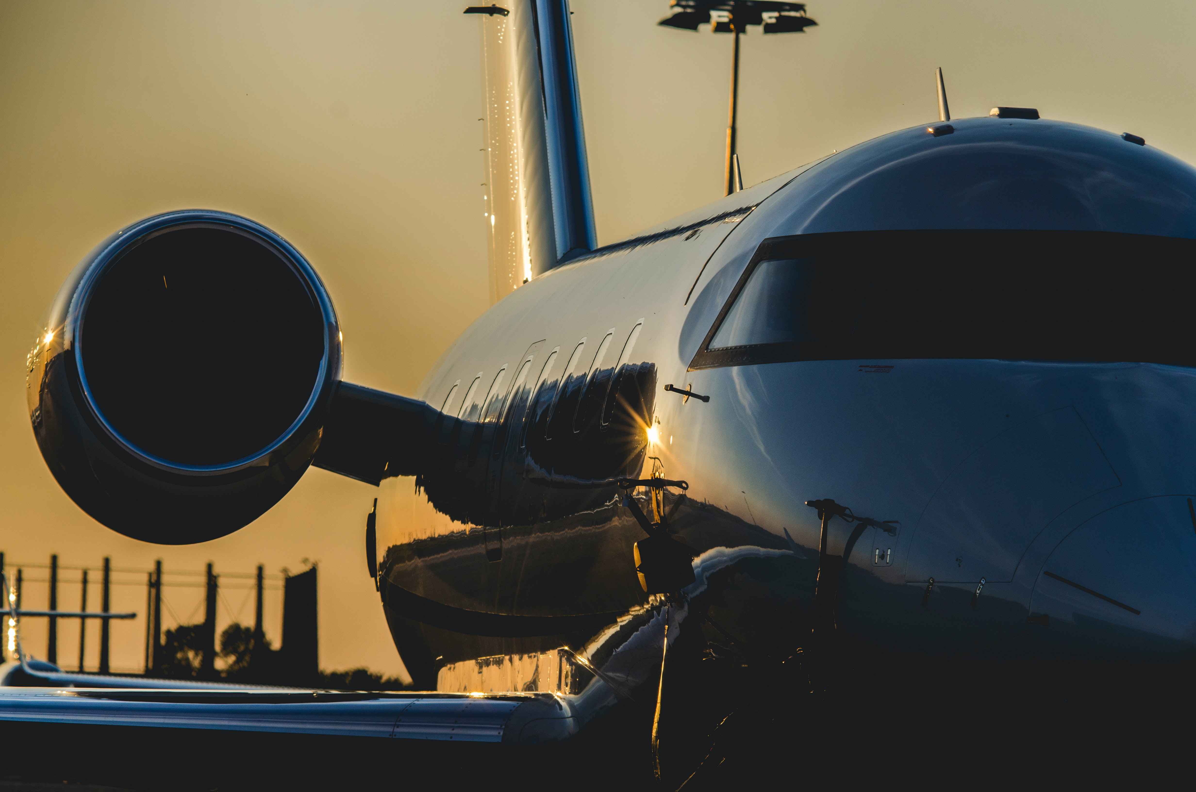 A private jet taxiing on a runway during sunset.