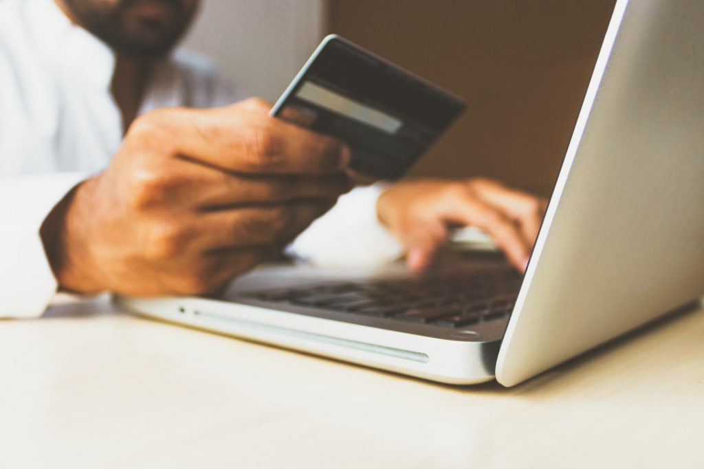 A person ordering goods through an eCommerce website, holding a credit card.