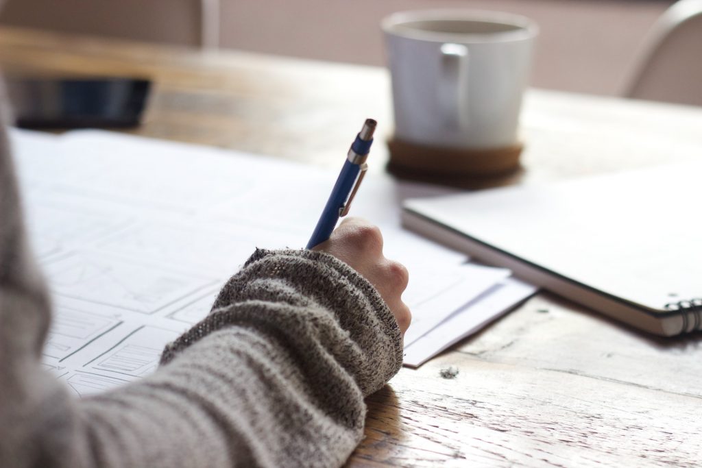 A woman taking notes on paper.